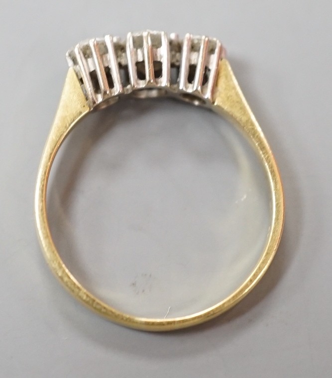 A modern 18ct gold and three stone diamond ring, size O, gross weight 2.5 grams.